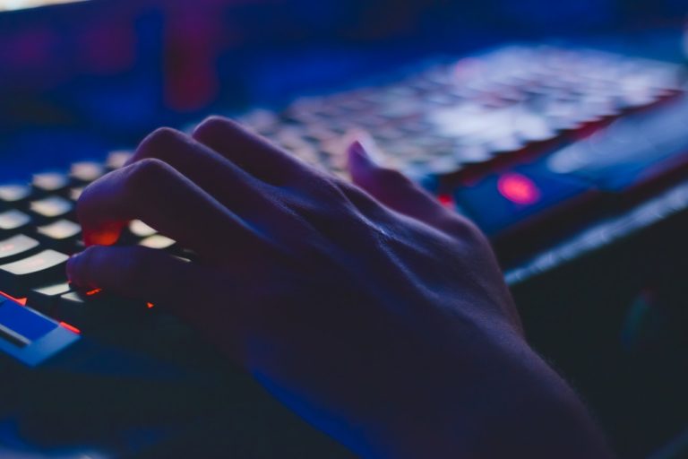 Person spiller computer med et tastatur med lys i